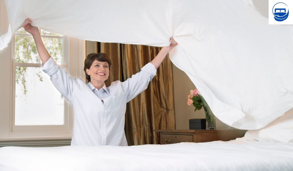 Femme qui change les draps d'un lit